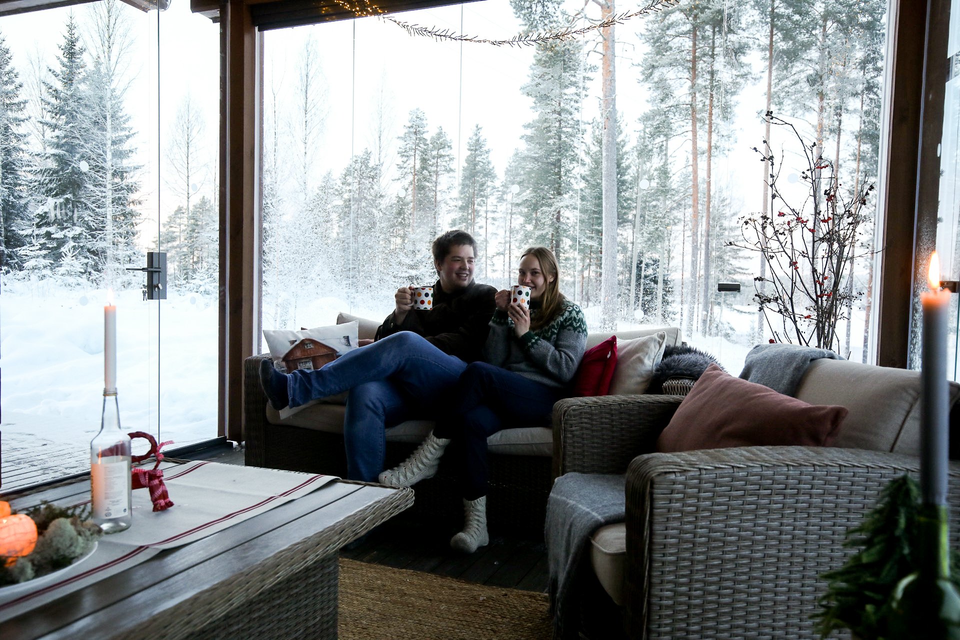 Couple drinking hot chocolate in wintery sunroom