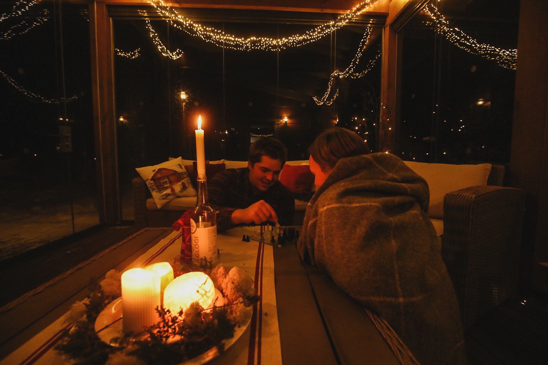 Couple playing boardgames in candlelight in sunroom