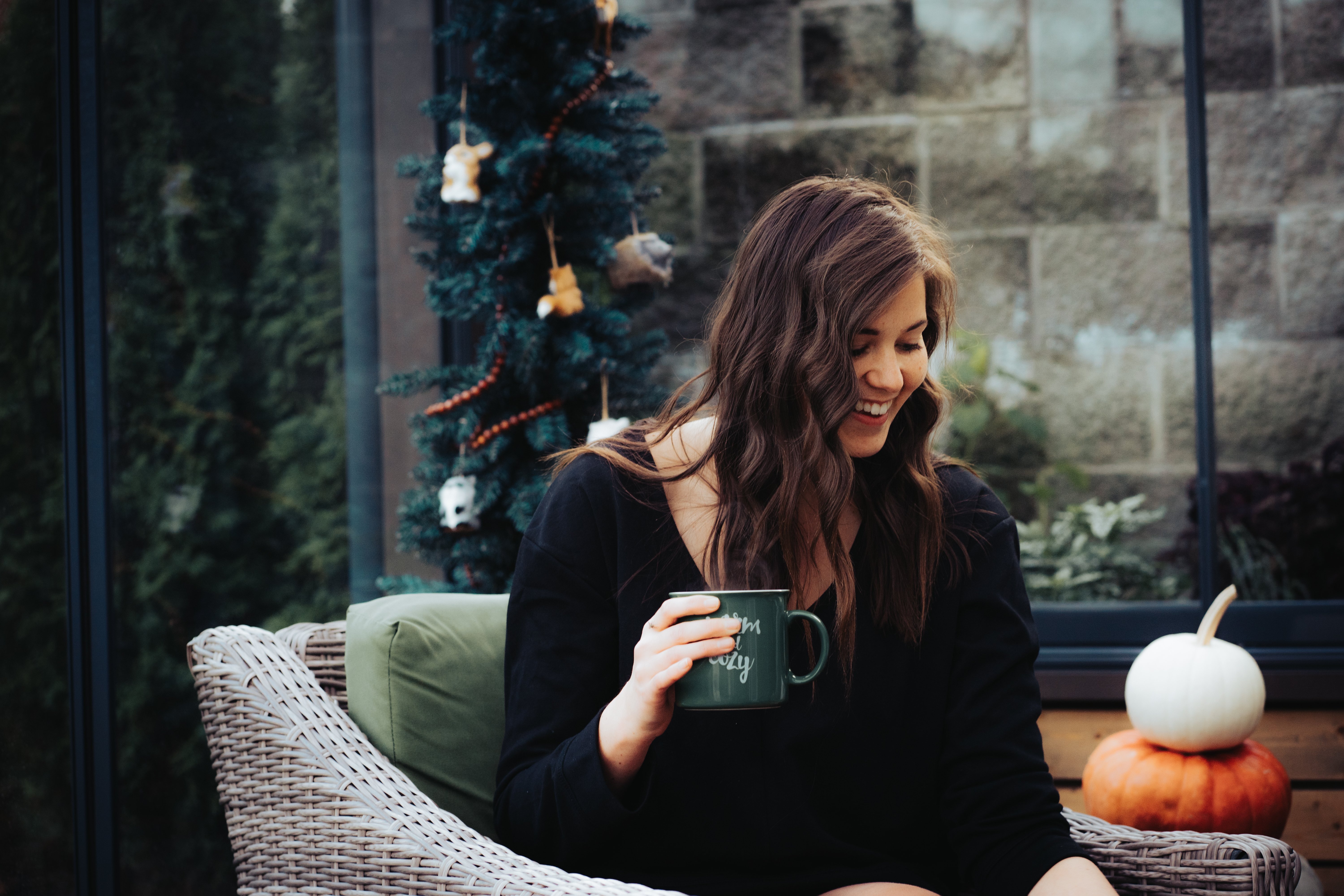Woman sitting in sunroom with a cup of hot chocolate